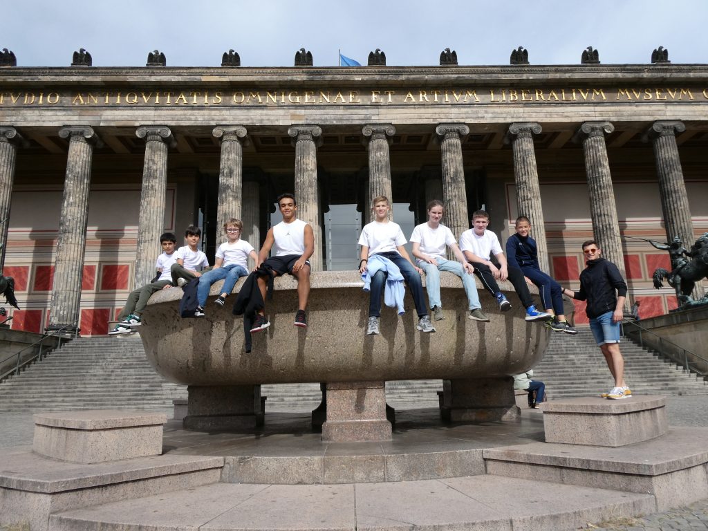 Acht Judoka mit A. Brain auf einem Brunnen vor dem Museum sitzend.