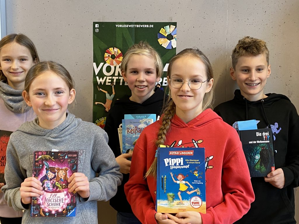 Stolze Schülerinnen und Schüler mit ihren Büchern