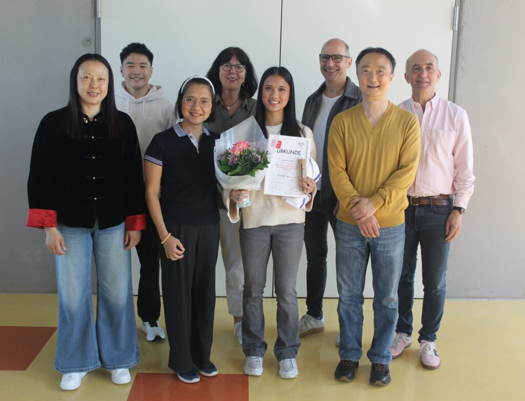 Elisa mit Familie und Lehrern, Urkunde und Blumenstrauß